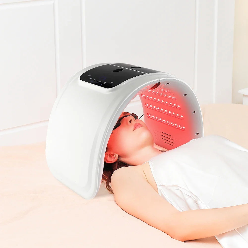 Woman using the LED light therapy canopy for facial skincare at home